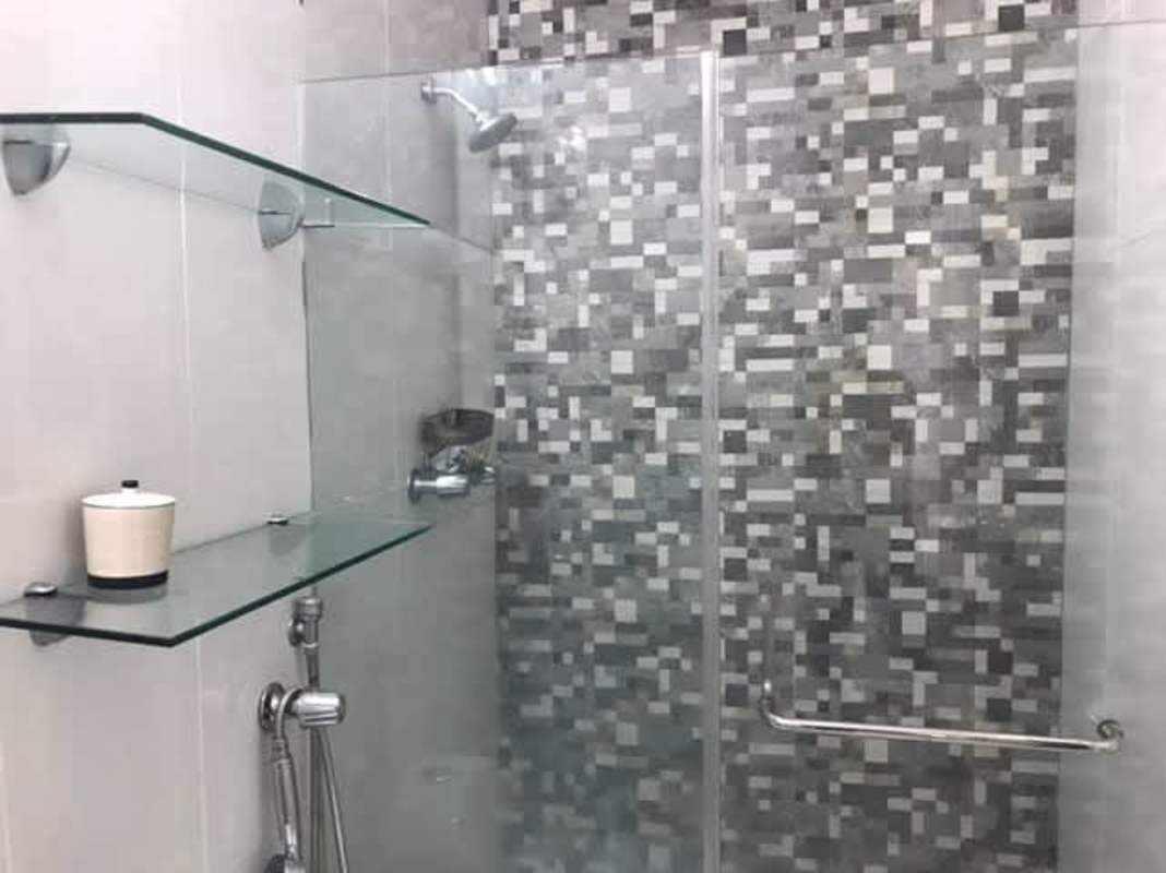 Minimalist white living room with tiled flooring built-in shelves Brisas del Golf Panama home