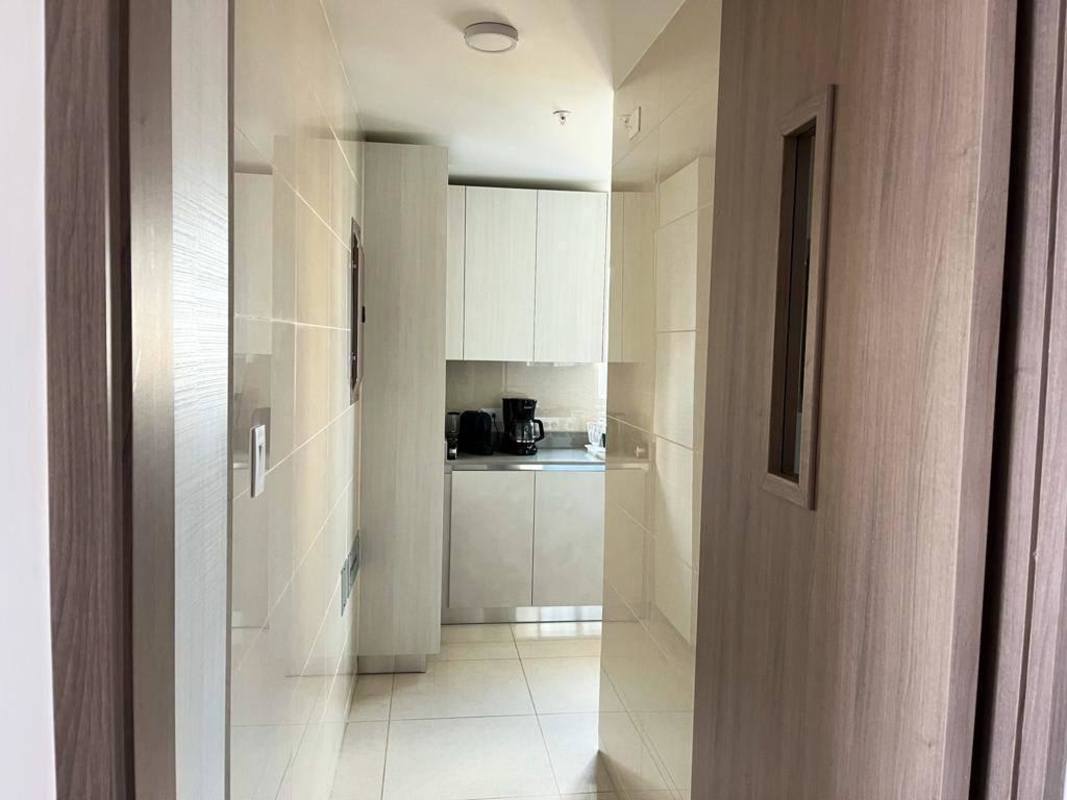 Sleek kitchen with marble countertop, wood cabinetry, ocean view PH Costanera Panama City