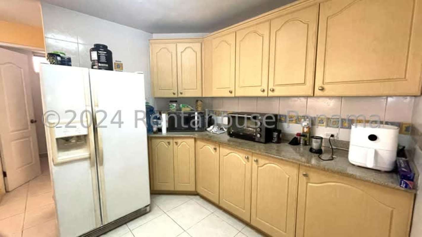 Modern living dining area with natural light, large windows, blue accent wall, white tile floor in Dorado Lakes Panama