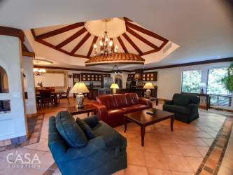 Custom luxury kitchen with large crescent island, granite counters, dark cabinets in Boquete home