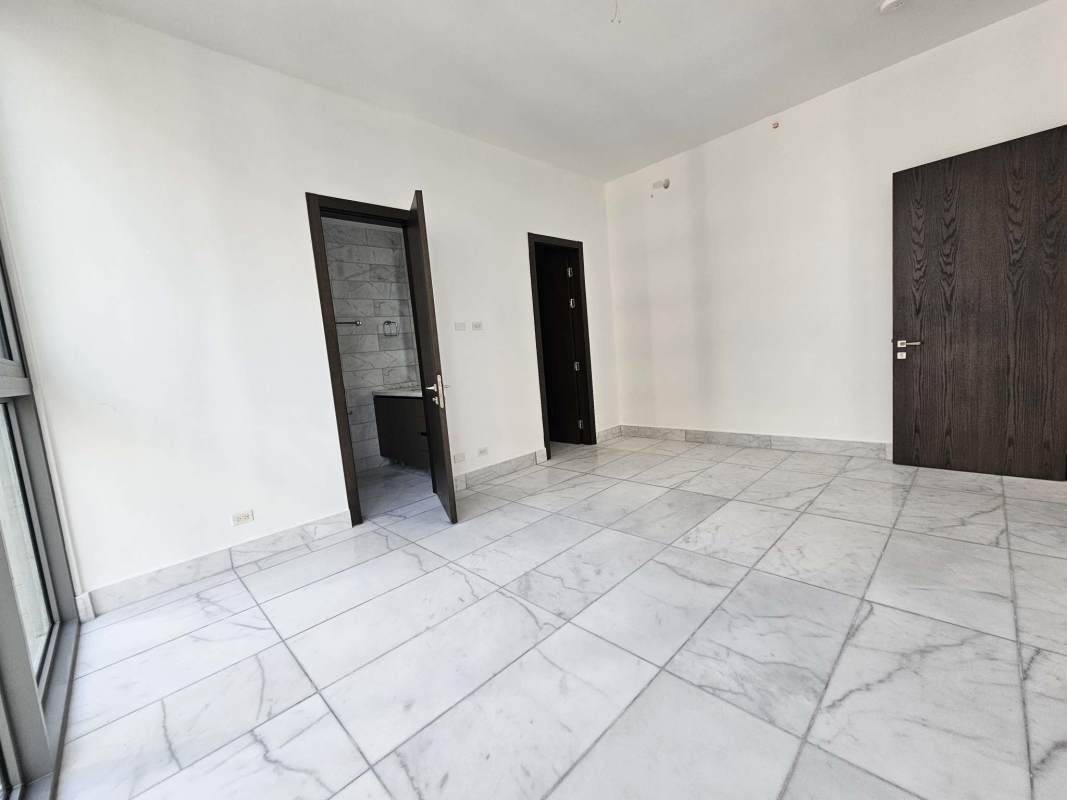 Spacious living room with marble floors, panoramic windows and city view at Seapoint Punta Paitilla in Panama City