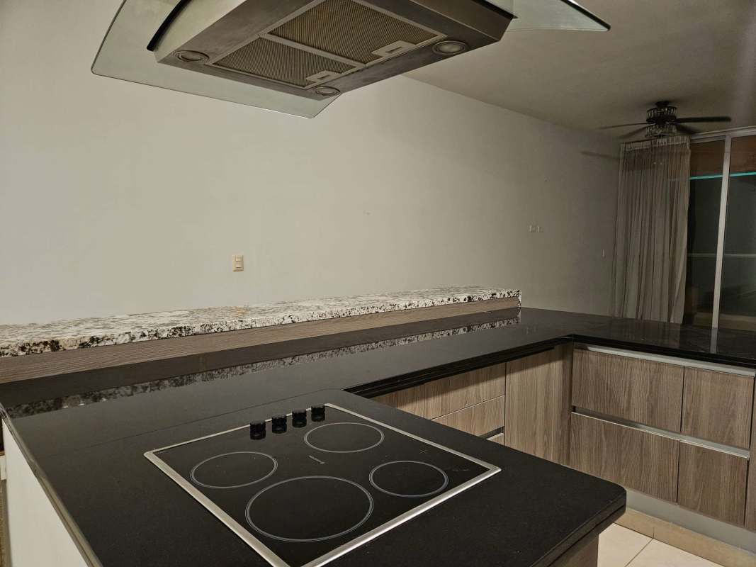 Open kitchen with granite countertops, electric cooktop, wood cabinets at Rivage Tower Panama City