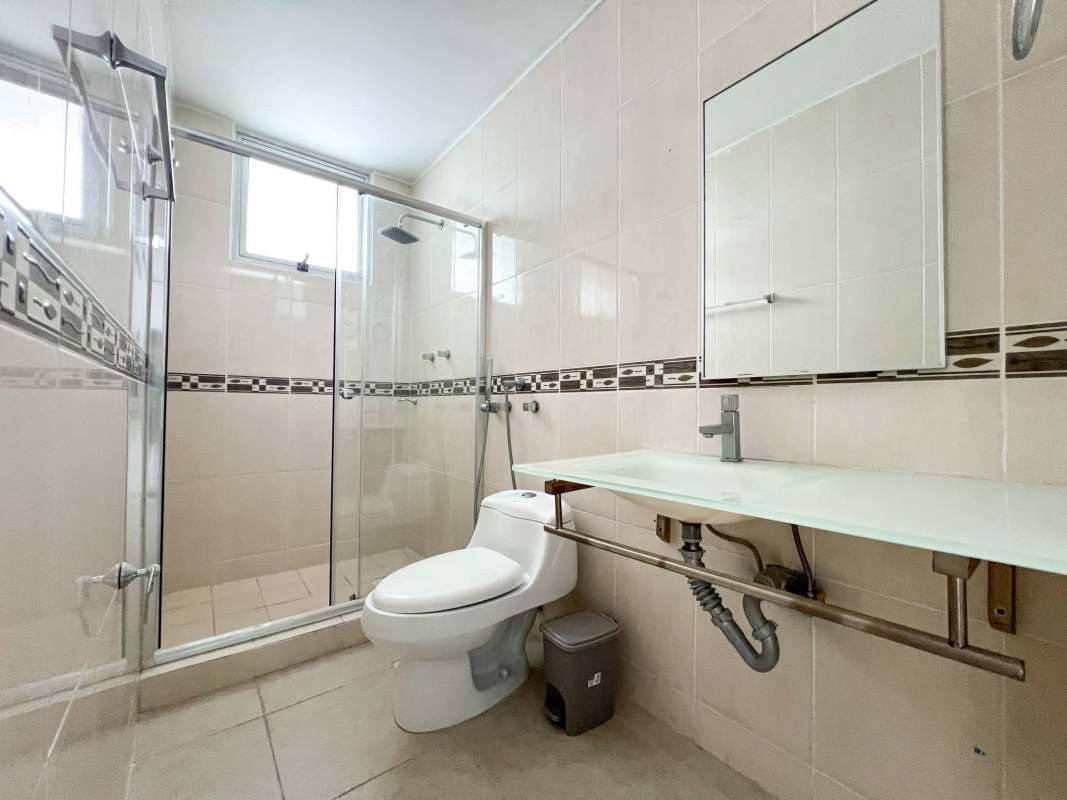 Stylish minimalist bathroom with glass shower tiled walls residential Clayton apartment Panama