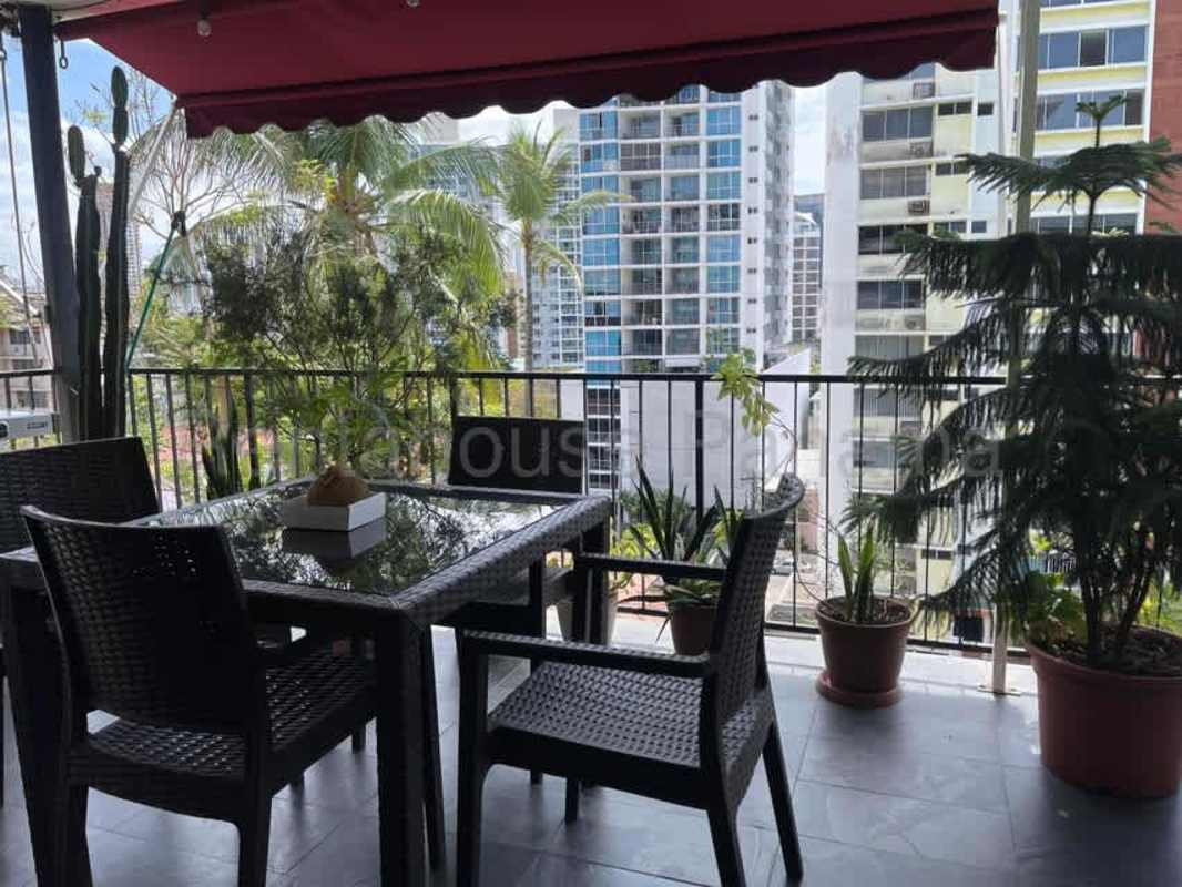 Spacious balcony with red awning, potted plants, city view El Cangrejo Panama