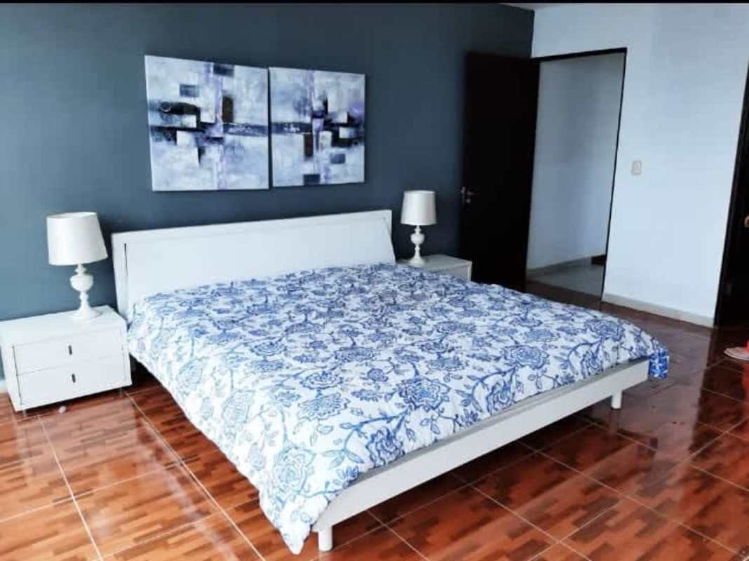 Dining room with glass table, wall art, wood floors, skyline view PH Park View San Francisco Panama