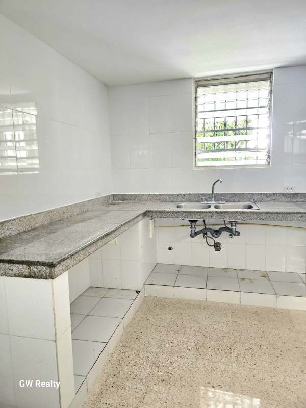 Kitchen with granite countertops, double sink and white tile backsplash Betania Panama