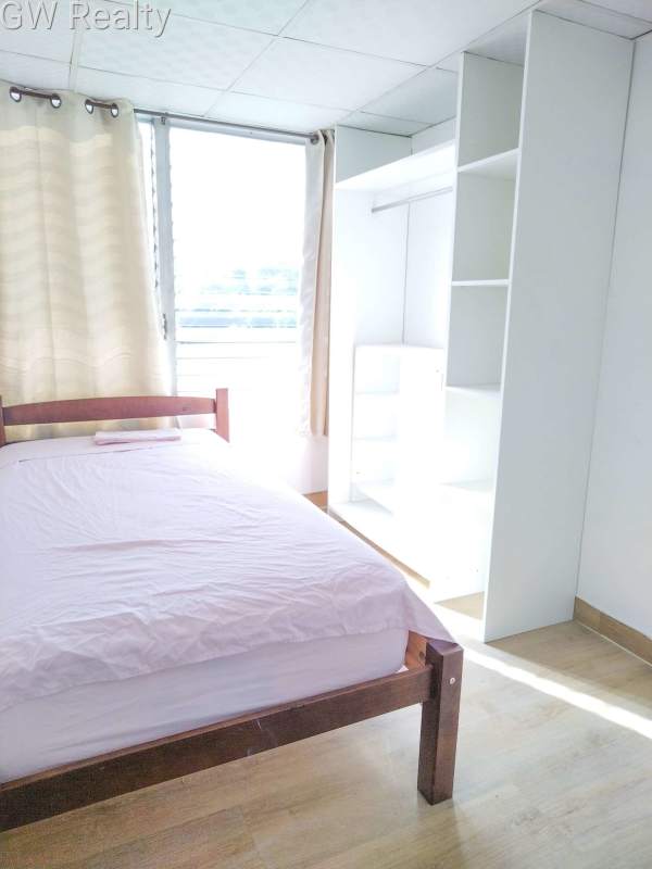 Small bedroom with built-in storage desk window blue curtains PH Bogotá El Cangrejo Panama