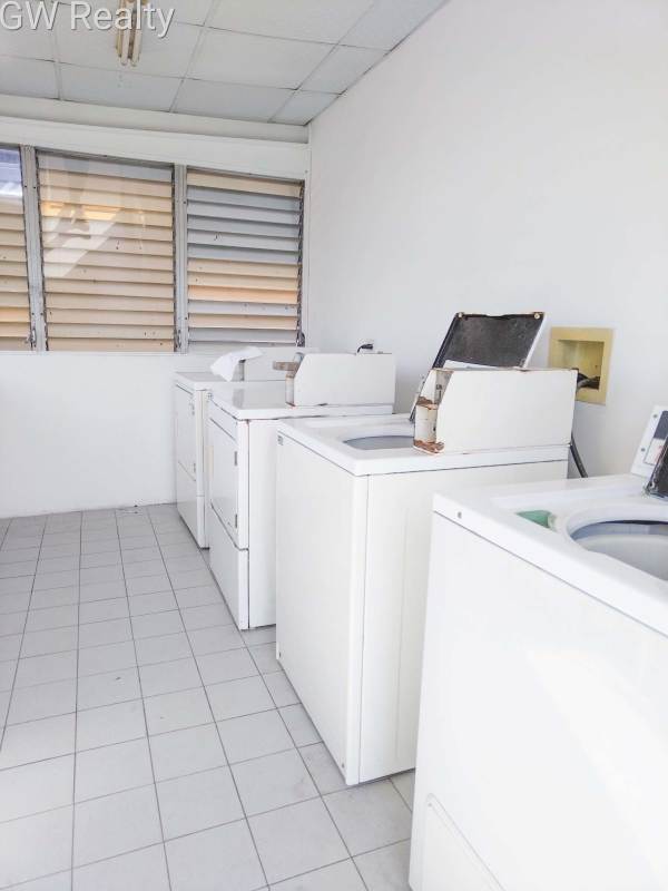 Minimalist bedroom with teal curtains closet tiled floor in PH Bogotá El Cangrejo rental property Panama City