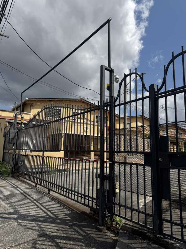 Exterior view with yellow building and metal gate at Quintas de Cerro Viento duplex Panama City