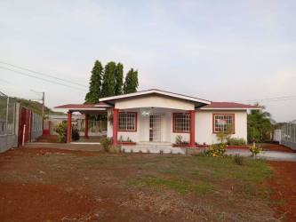 Large blue water reserve tank fenced beside house Jardines de la Riviera David Panama