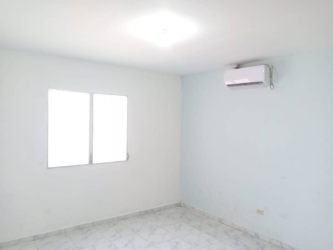 Living room with tiled floors white walls and pass-through kitchen Jardines de la Riviera David Panama
