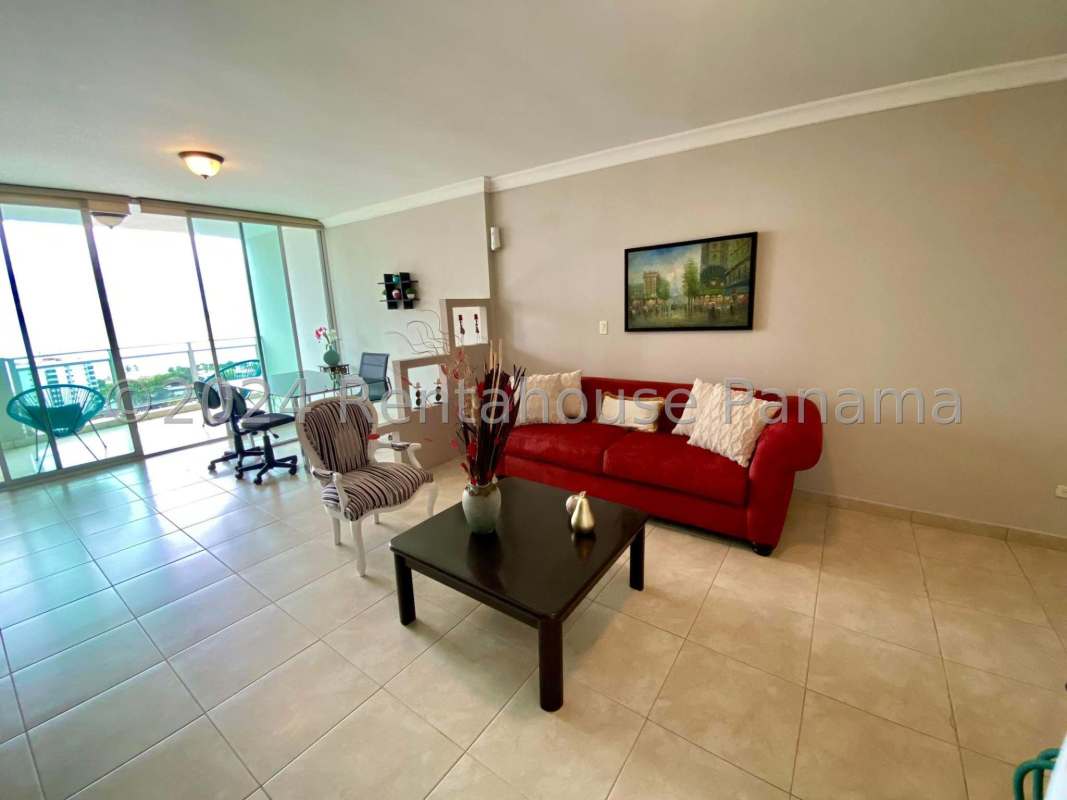 Open-plan living room with balcony access featuring floor to ceiling glass doors in Punta Pacifica Panama