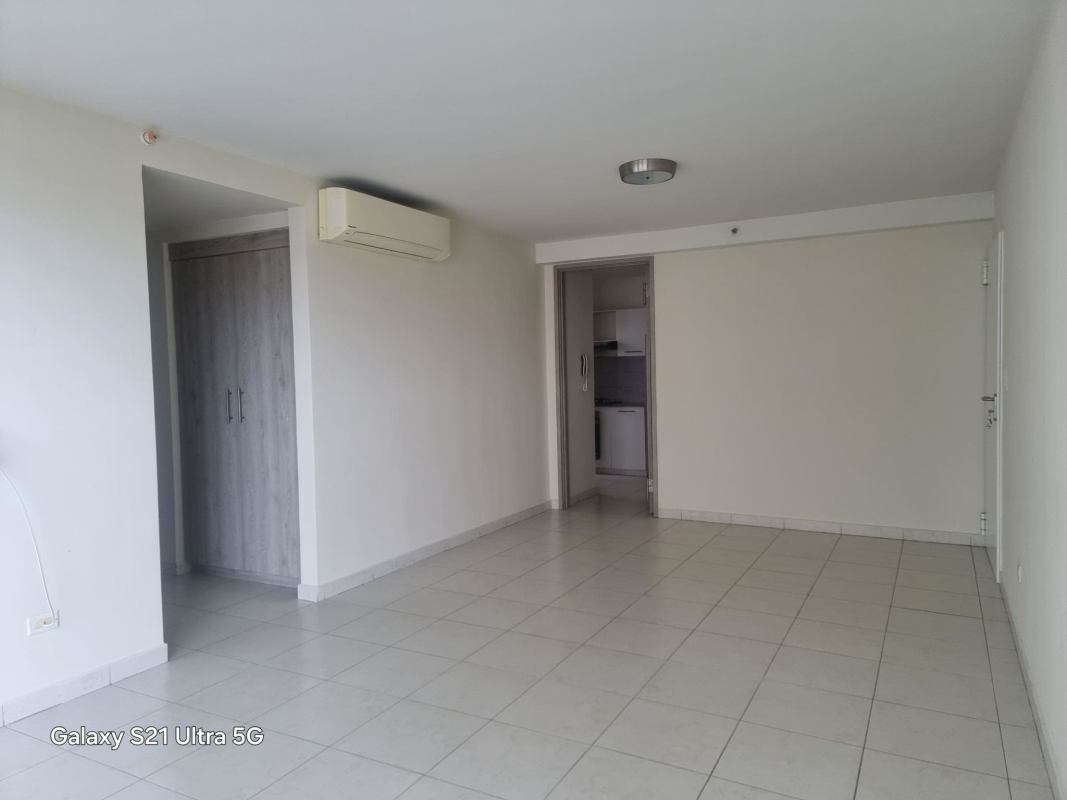 Bright apartment living room with split AC, tiled floors, and access to balcony in PH Torres de Versalles