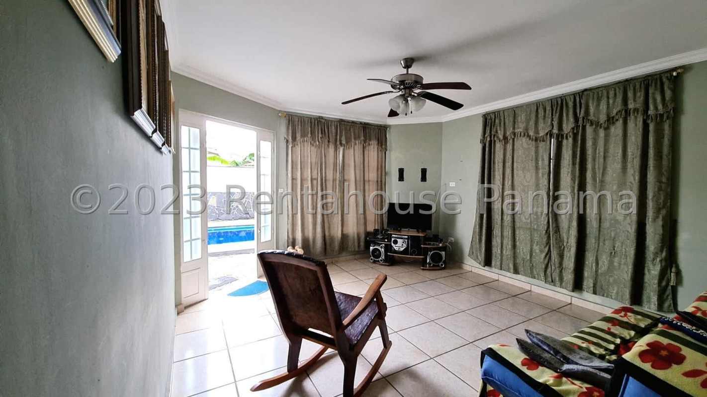 Covered outdoor terrace with bar counter and fans overlooking pool in Terrazas de Brisas del Golf