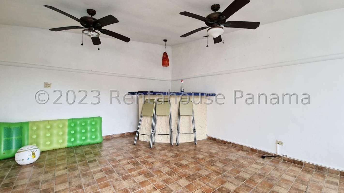 Indoor recreation room with bar, fans, adjacent to poolside terrace in Brisas del Golf Panama