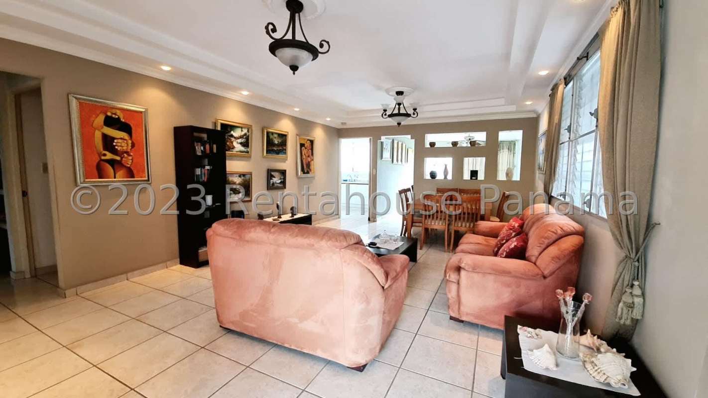 Living area with ceramic tile floor, ceiling fan, window with curtains, access to patio and pool
