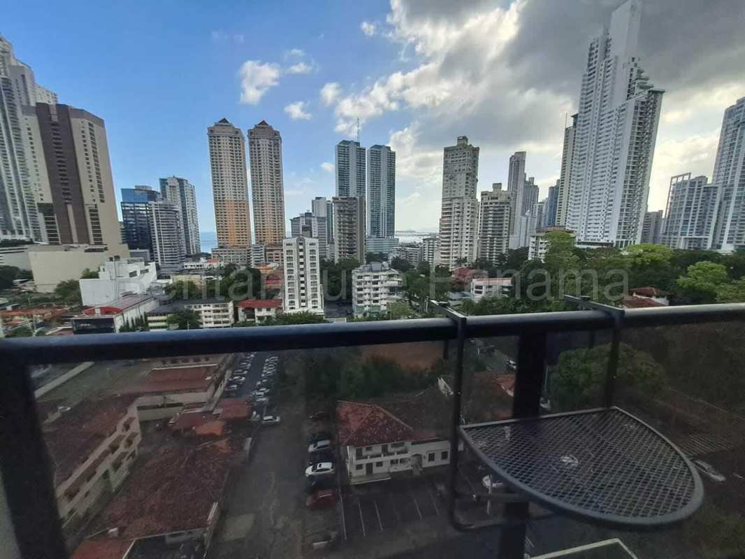 Balcony with glass railing overlooking Panama City skyline and ocean PH The Gray