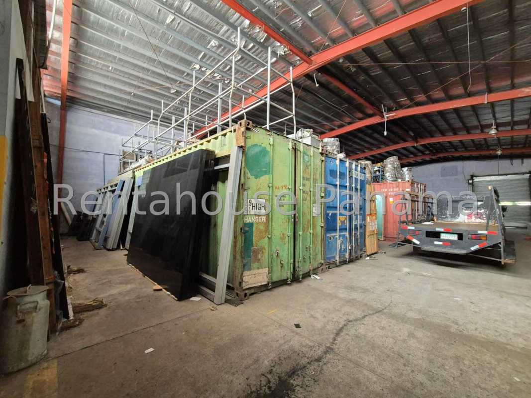 Wide paved parking lot adjacent to commercial warehouse building with ample maneuvering space