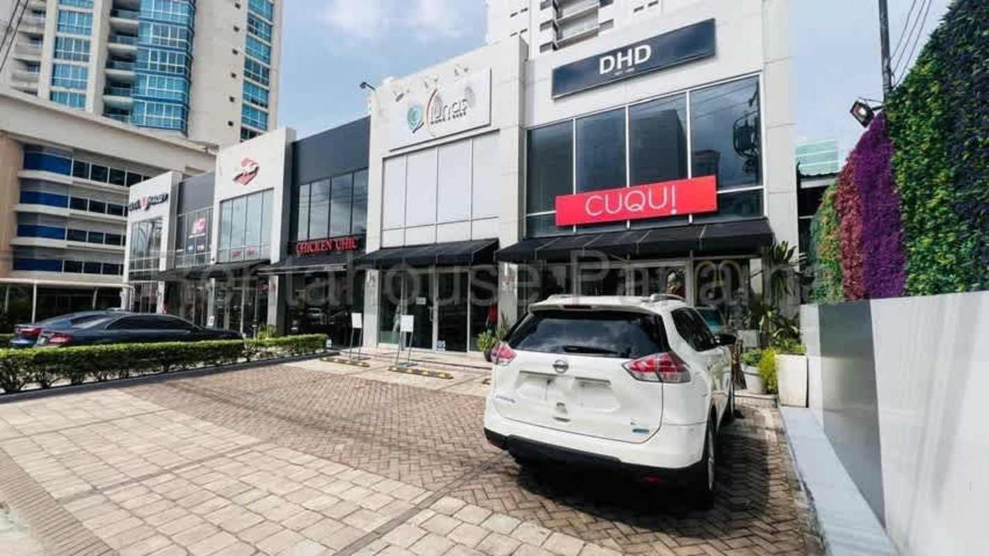 Modern cafe space with large windows, high tables, festive string lights and wall art in Panama City retail plaza