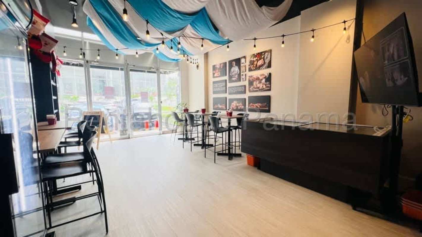 Bright cafe seating with decorative ceiling, string lights and windows in Panama retail plaza