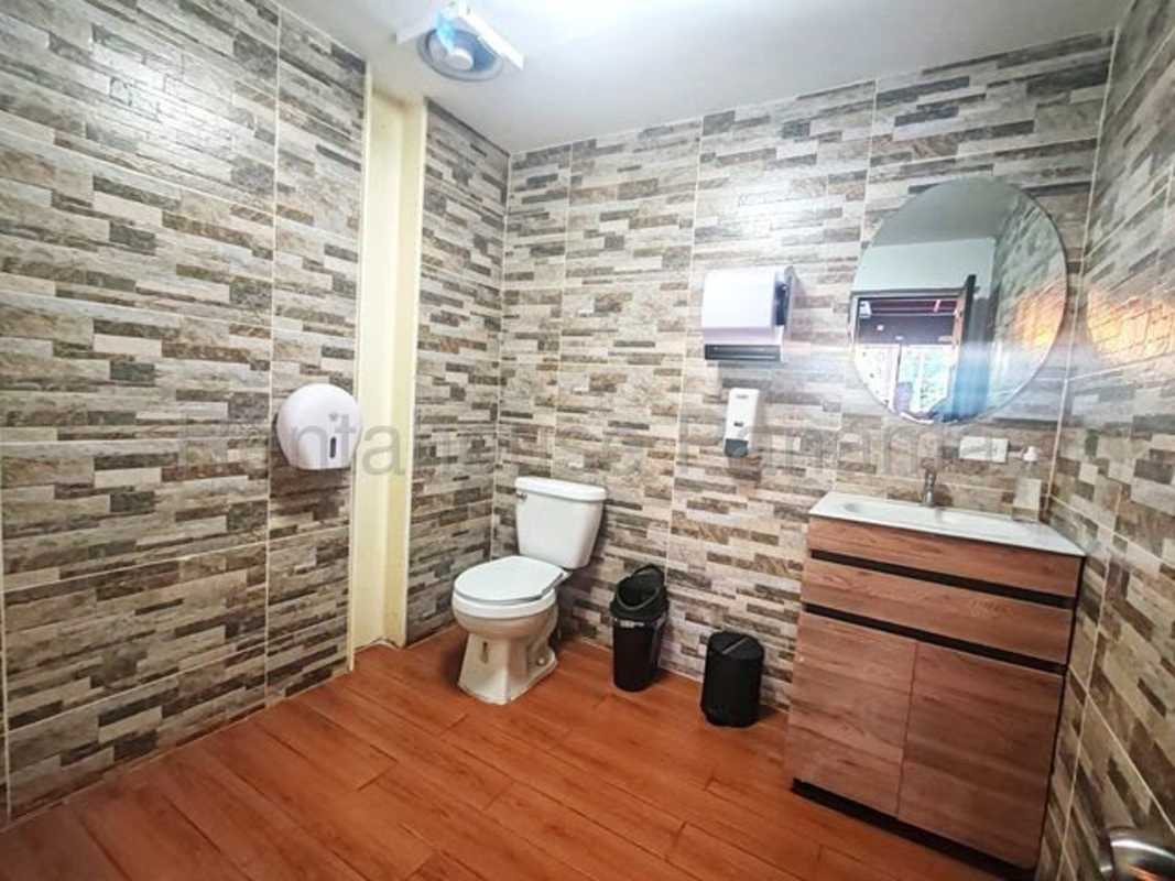 Industrial cafe interior with red beams, fridges, pendant lights in Plaza El Cangrejo Panama