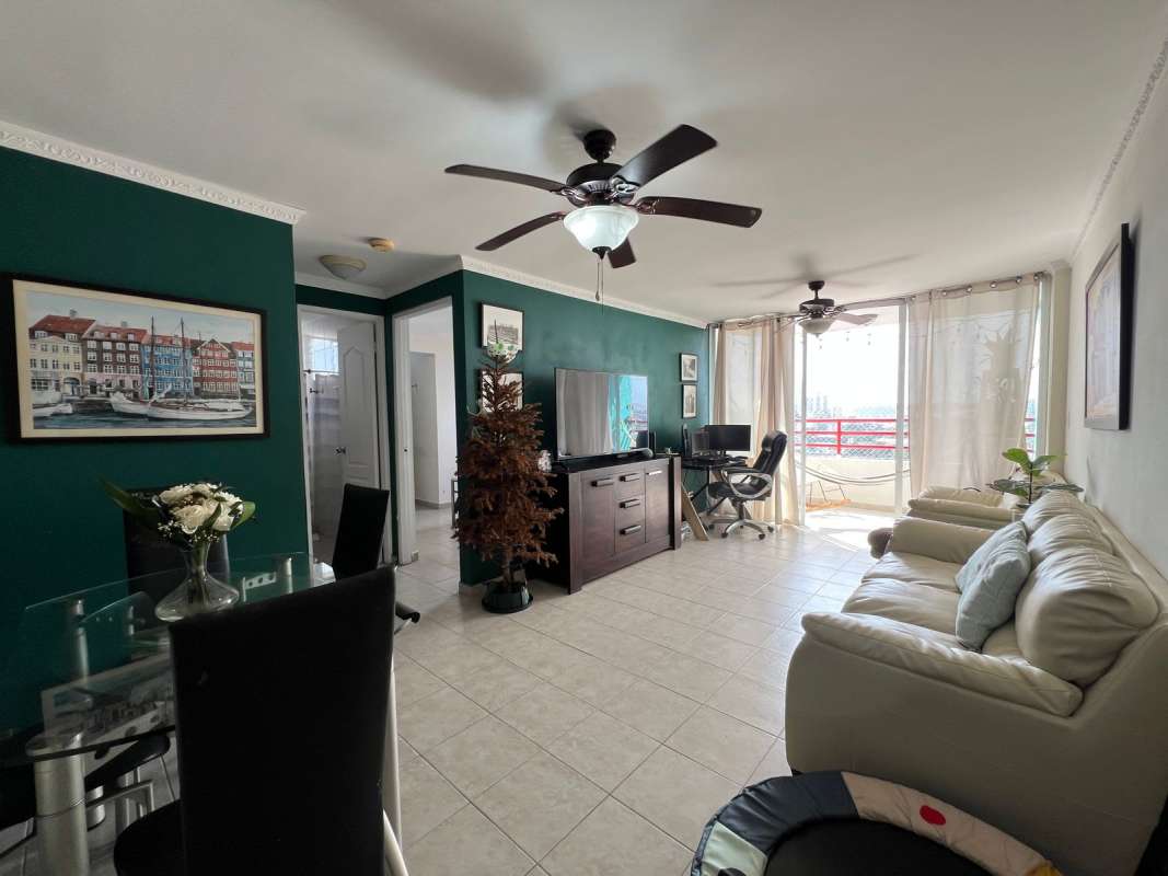 Open kitchen with granite countertops, wood cabinets, teal accent wall near Fernandez de Cordoba Panama