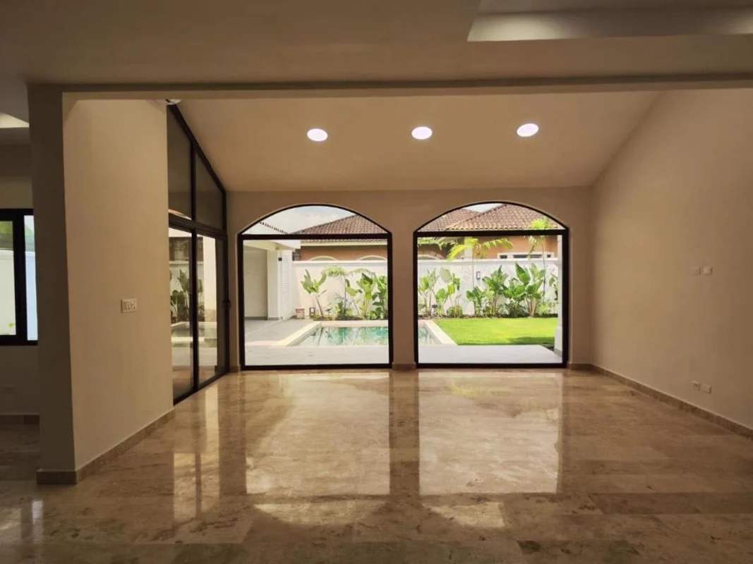 Spacious living room with marble floor and glass doors overlooking pool and garden Costa Sur Panama