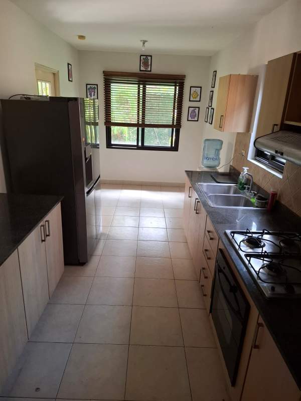 Kitchen with granite counters, gas stove, and refrigerator in rental house Versalles Panama