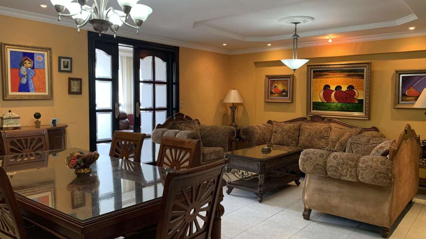 Spacious living and dining space with beige walls, artwork, and wooden furniture in PH Señorial 50 Panama