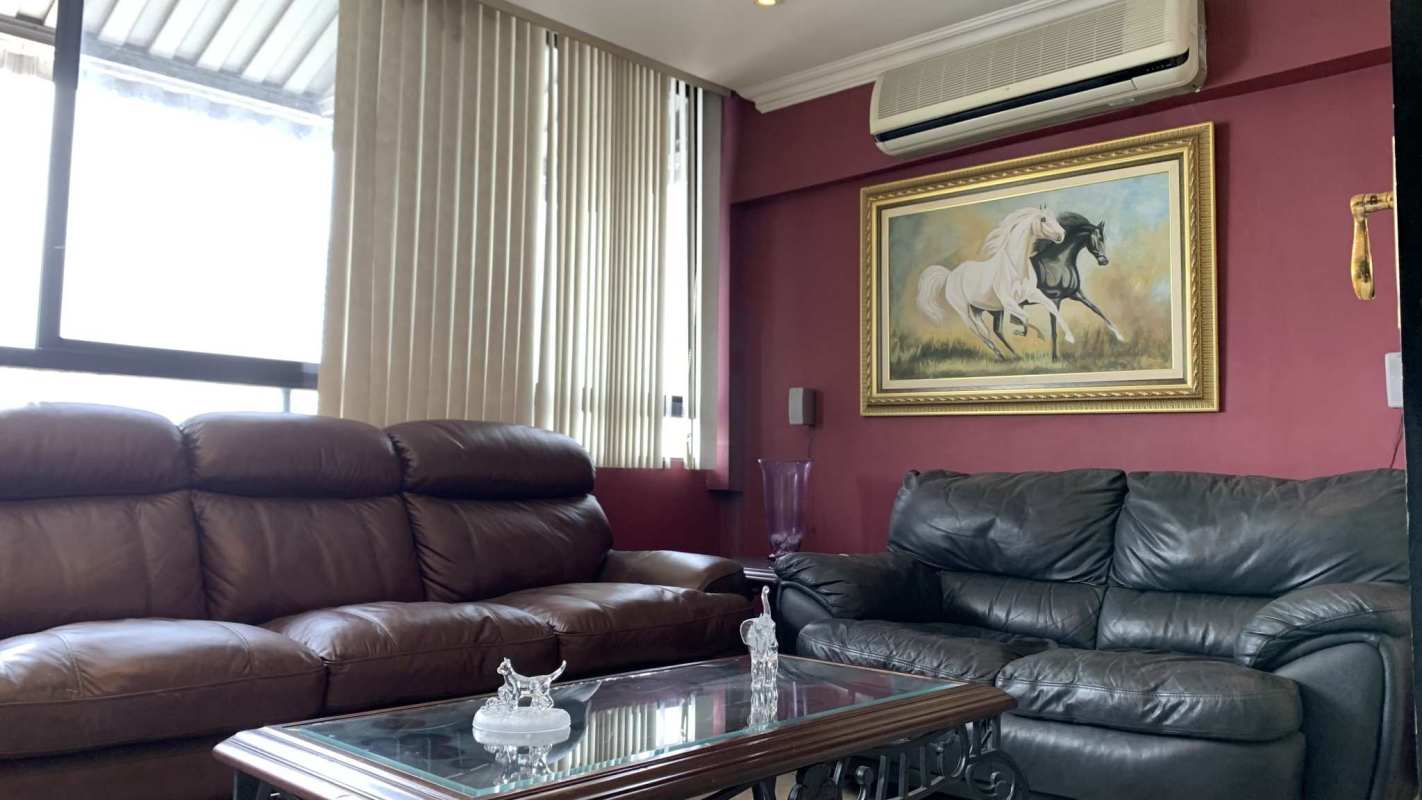 Spacious open living and dining room with chandelier, beige walls, wooden furniture in PH Señorial 50 Panama City