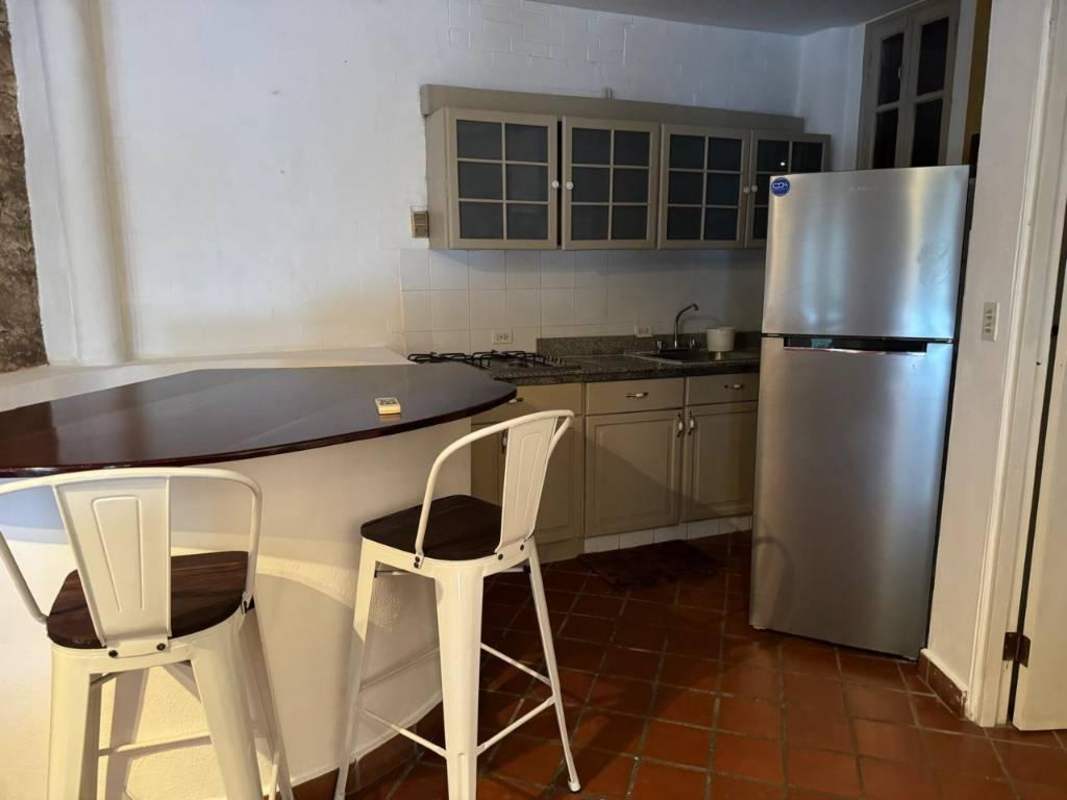 Cozy bedroom with stone wall, colorful decor, ceiling fan in Casco Viejo Panama City