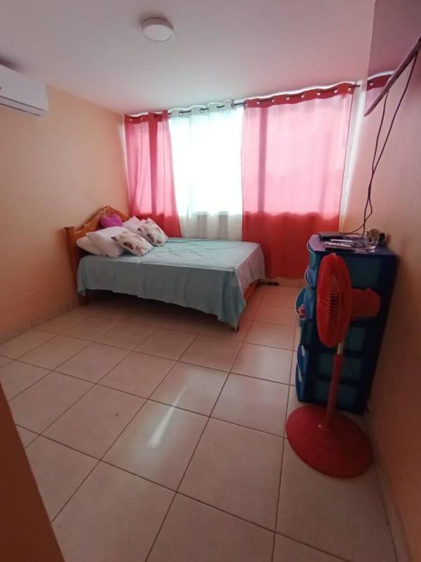 Empty bedroom with marble accent wall, large window, white tiled floors in PH Central Park.
