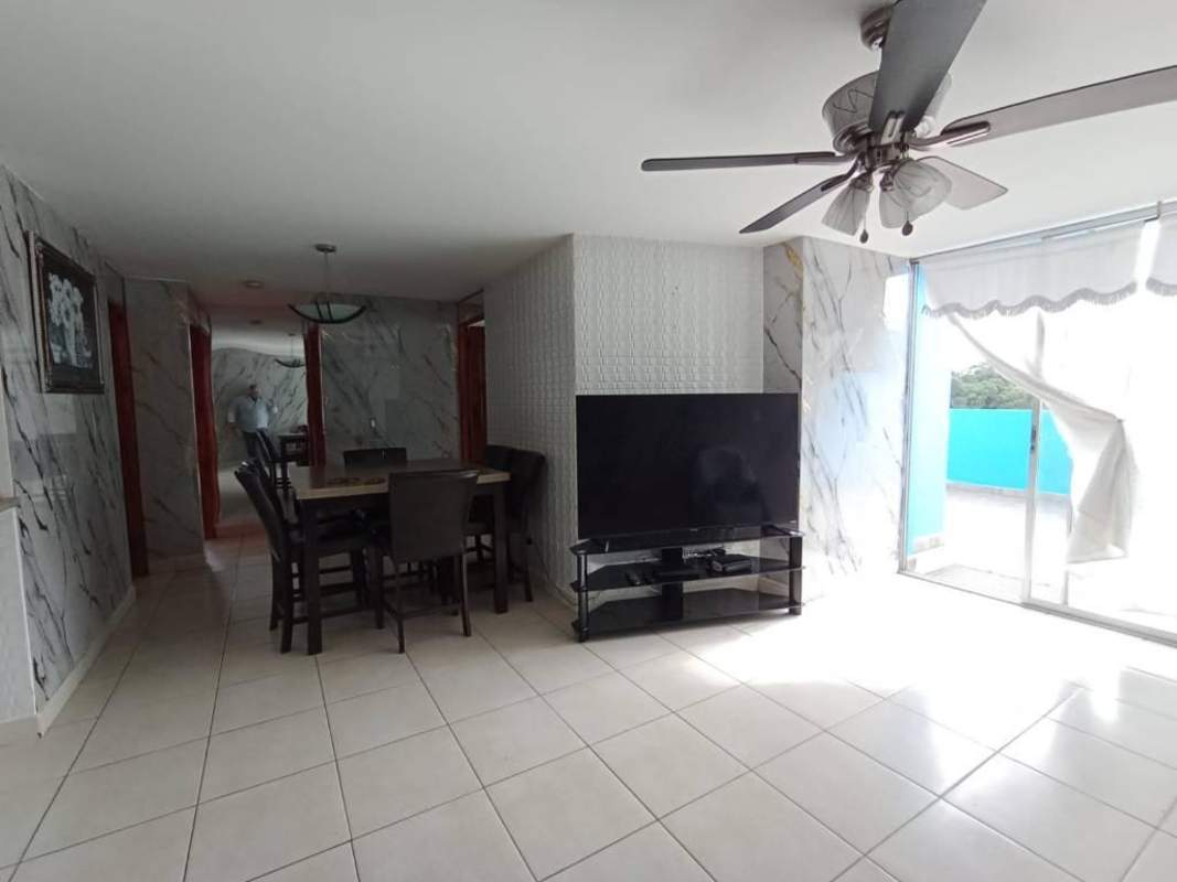 Modern living room with marble accents, TV, dining area and sliding doors at PH Central Park apartment.
