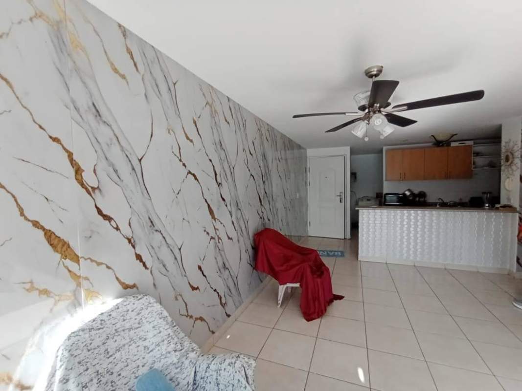 Kitchen area with breakfast bar, marble accents, appliances in Central Park Panama City apartment.