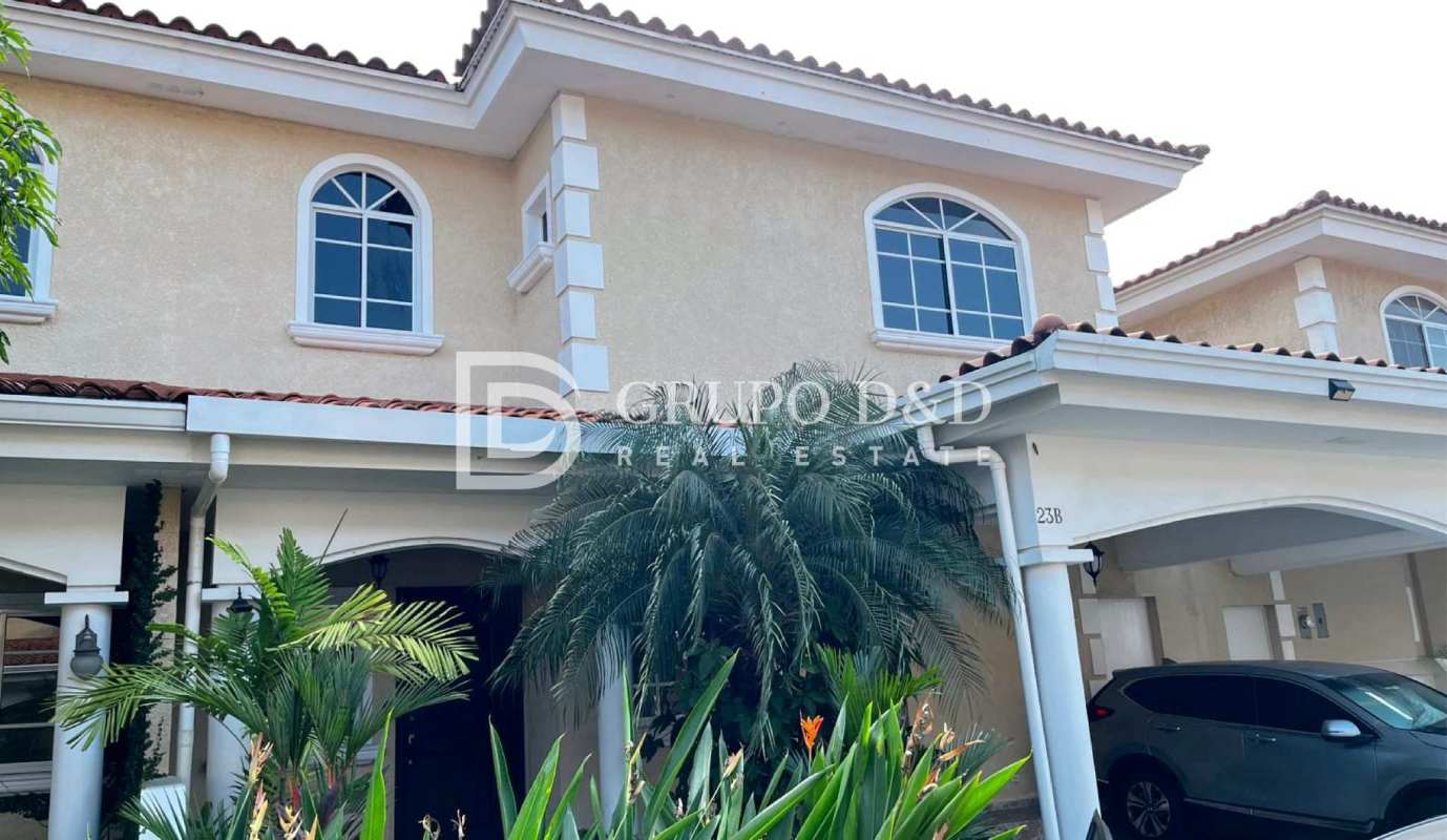 Facade with terracotta tiles, arched windows, and lush garden Costa del Este Panama