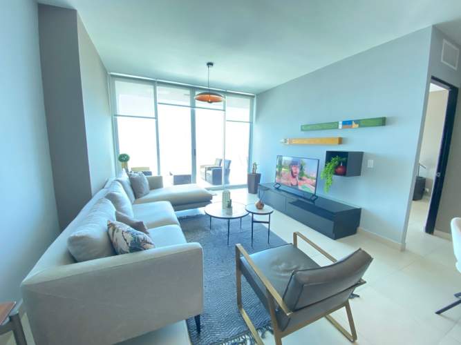 Modern open kitchen with dining table and island at furnished apartment PH BICSA Avenida Balboa Panama