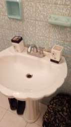 Traditional bathroom with mosaic wall, pedestal sink and chrome faucet Colón