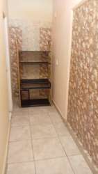 Interior hallway with stone-patterned tile walls in apartment Colón