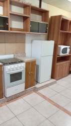 Kitchen with wood cabinetry and appliances in apartment Barrio del Maestro Colón