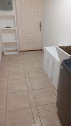 Multi-use laundry with washer and utility sink in furnished apartment Colón