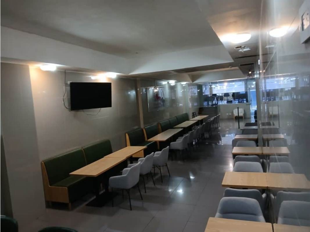 Dining hall with glass partitions, wooden tables, gray chairs at Avenida Justo Arosemena