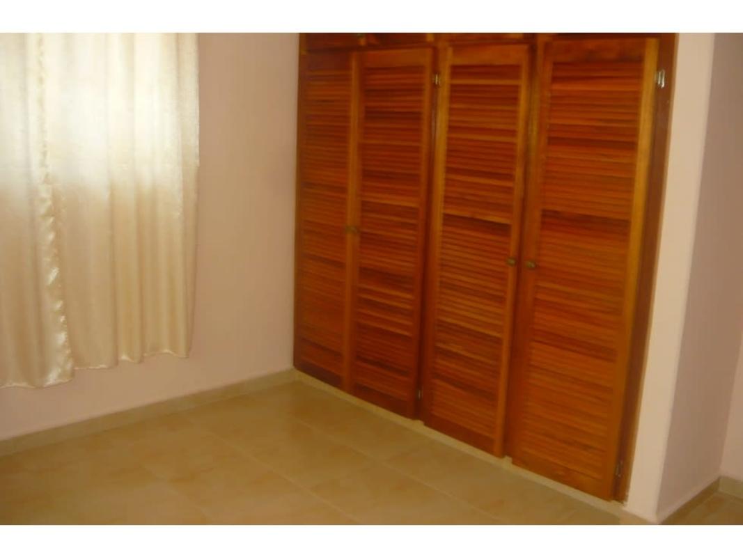 Single-story peach house with tiled roof, driveway, carport and garden in San Miguelito