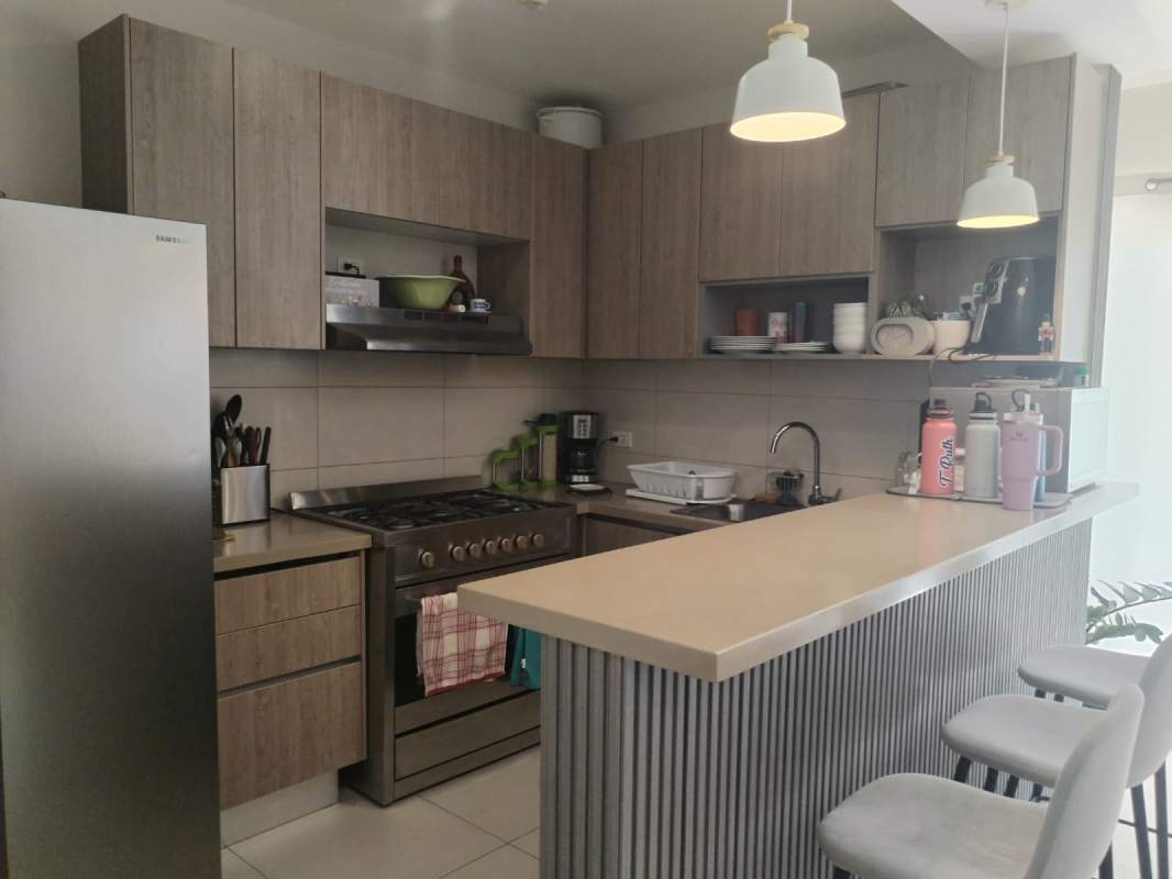 Kitchen with wood cabinets, granite counters, appliances at PH Costa Linda, Costa Sur Panama