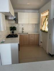Remodeled kitchen with window light, modern cabinets, cooktop and oven Brisas del Campo