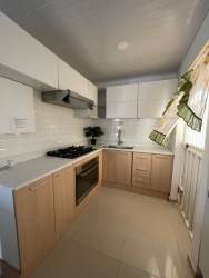 Modern kitchen with gas cooktop, oven and tile backsplash in rental house Brisas del Campo