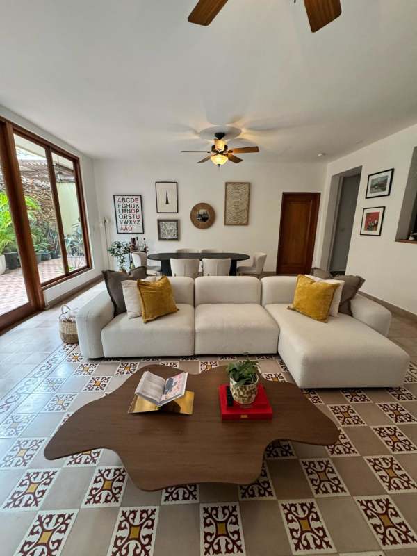 Living room with stone floors, ceiling fans, colonial wood features at Casco Viejo apartment Panama
