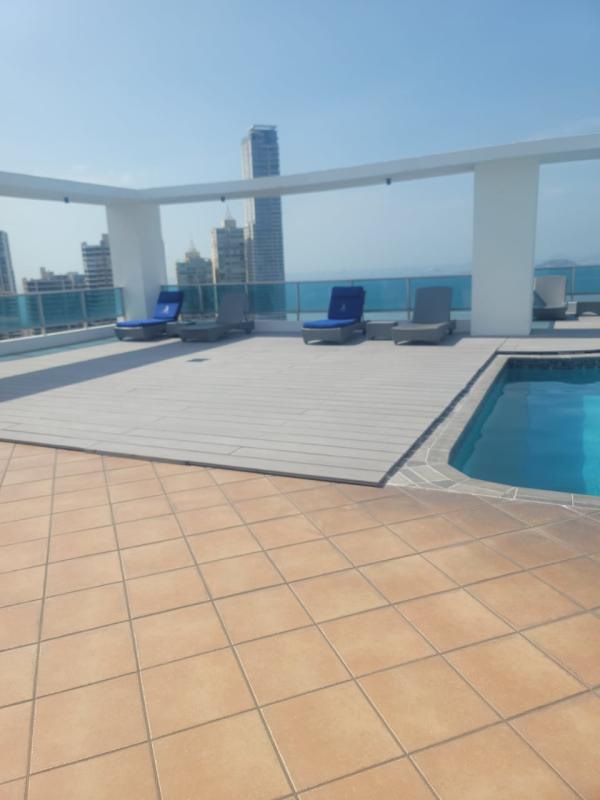 Living room with cream sofas, panoramic windows and skyline views at PH Grand Bay Avenida Balboa