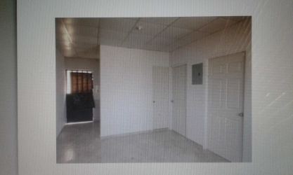 Apartment complex exterior with covered walkway, gravel garden and parking Santiago Panama