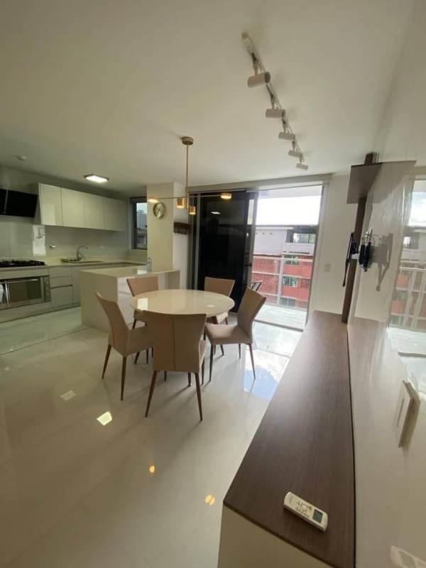 Dining space with round table, upholstered chairs, near kitchen PH Velure Panama City