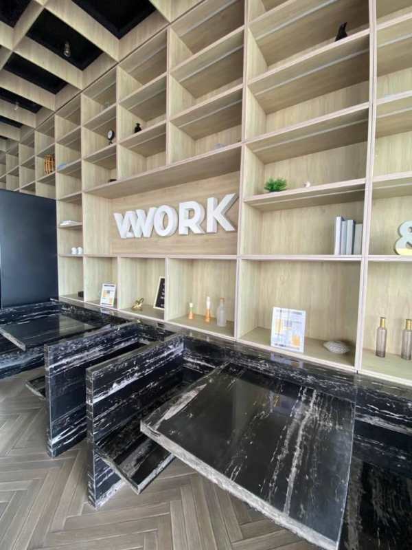 Co-working lounge with bookshelves, blue chairs, wood flooring PH Velure Panama